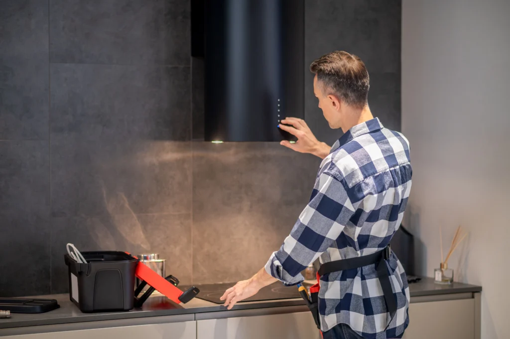 Electrician in Solihull is repairing kitchen appliance